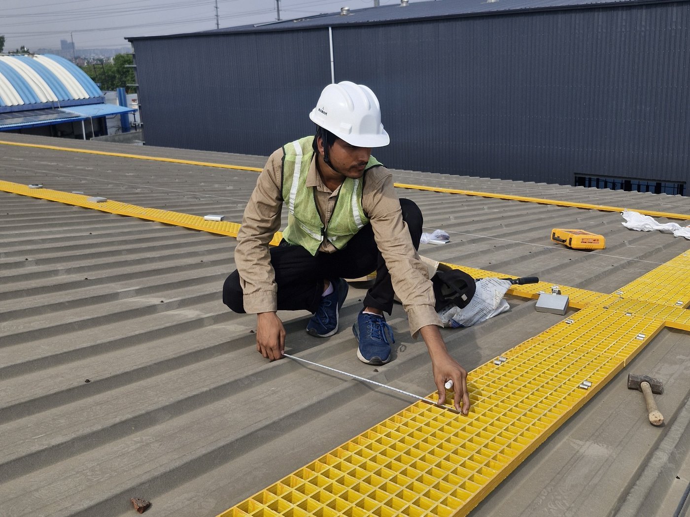 Evolve Energy technician installing rooftop walkway grating